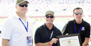 Gunnery Sergeant Eric Dueweke presents Keith Wilson, Affinia CEO and Paul Kortman, brand manager NAPA Filters a certificate of appreciation for NAPA Filters' support of the Intrepid Fallen Heroes Fund.