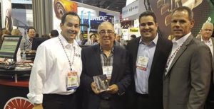 The AAPEX 2015 award presentation. From left to right: John C. Washbish, account executive, NGK Spark Plugs (U.S.A.) Inc.; Juan L. Vento, owner, Vento Distributors Corporation; Javier Vento, vice president, Vento Distributors Corp.; Mike Schwab, senior vice president; NGK Spark Plugs (U.S.A.) Inc.
