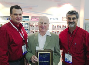 (left to right) Roger Bird, Philips national sales manager; David Weiss of Marc Alan Associates; and Dennis Samfilippo, Philips general manager during awards ceremony at Philips’ AAPEX booth. The Oakland, N.J.-based agency has represented Philips for more than 32 years.