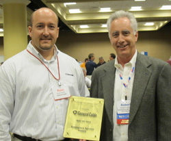 general cable’s ryan kiefer (left), regional sales manager automotive products, accepts the exemplary service award for a new vendor from apa vice chairman robert “bob” duxler (right) of automotive inventory management systems.