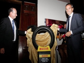 Rafael Navarro (left), PTNA vice president of communications, and Paolo Ferrari, chairman and CEO, unveil the first tire produced at the tiremaker’s plant in Rome, Ga., now on permanent display at the Rome Area History Museum.
