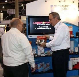 pete haskell shows an aapex attendee one of the new luber-finer marketing support pieces at the show.  