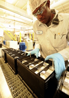 An Exide manufacturing associate examines an AGM battery being assembled in Columbus, Ga.